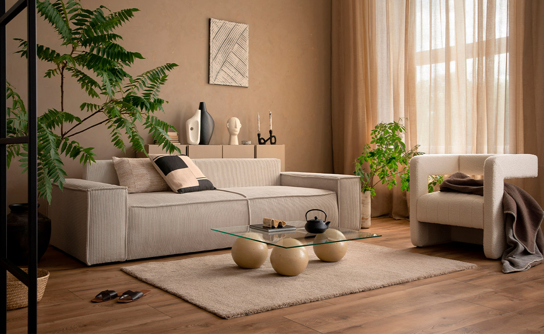 Cozy living room with a couch, coffee table, chair, plant, and window, illustrating modern Texas home entertainment concepts.
