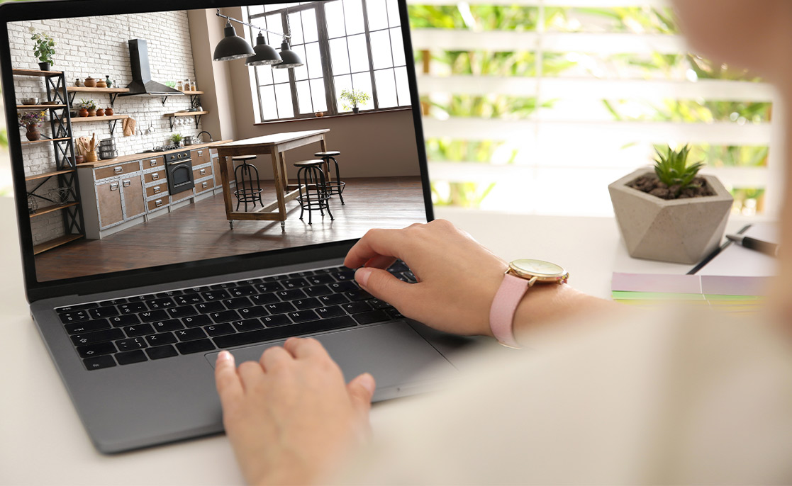 A woman views kitchen layouts on her laptop, seeking advice on selecting a custom home builder in McAllen.