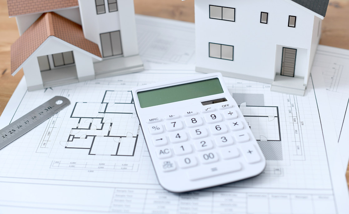 calculator, building plan and house models. 