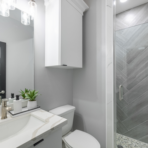 Modern bathroom design featuring sleek fixtures, herringbone tiles, and ample natural light.