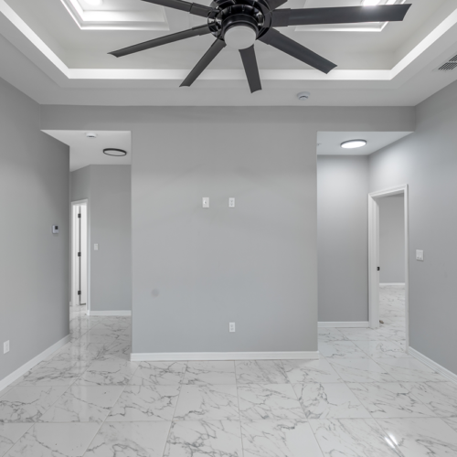 Modern living room with gray walls and marble tile flooring.