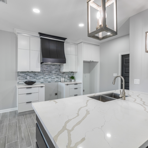 Modern kitchen with sleek cabinetry, marble countertops, and stylish pendant lighting.